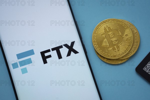 Dhaka, Bangladesh- 03 Sep 2025: FTX logo on smartphone screen near Bitcoin coin and QR code on blue