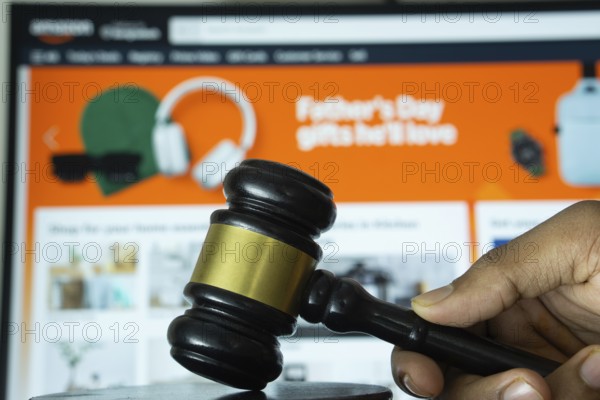 Dhaka, Bangladesh- 20 June 2025: A hand holds a gavel in front of a computer screen displaying
