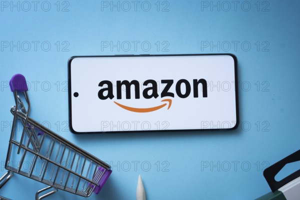 Dhaka, Bangladesh- 03 July 2025: Smartphone displaying Amazon logo with shopping cart on a blue