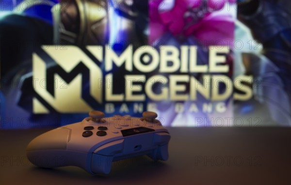 Dhaka, Bangladesh- 25 Aug 2025: A close-up of a white gamepad with Mobile Legends Bang Bang seen on