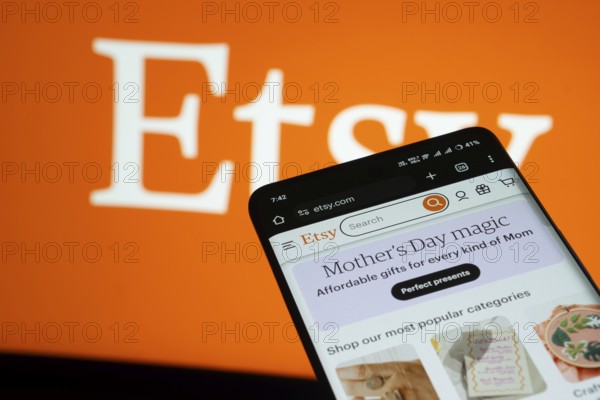 Dhaka, Bangladesh- 03 July 2025: Smartphone displaying Etsy web interface against Etsy logo