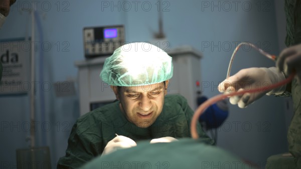 Several doctors performing a complex surgical operation inside an operating room for a displaced