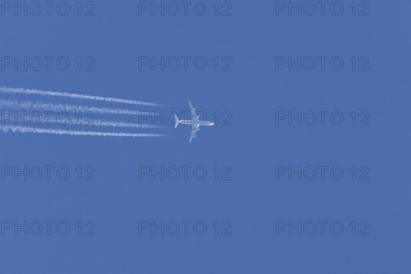 Airbus A340-300 jet aircraft of Lufthansa airlines in flight in a blue sky with vapour trails or