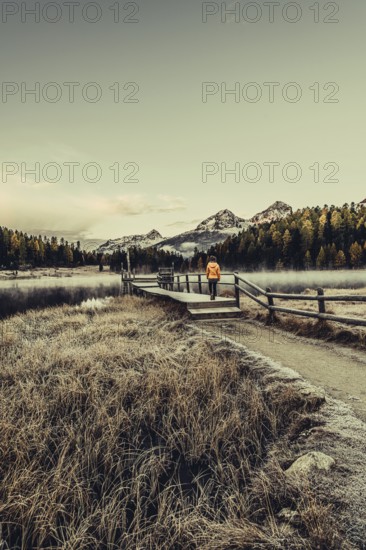 Young woman at Lake Staz near Sankt Moritz in the Engadine in Switzerland. Morning atmosphere with