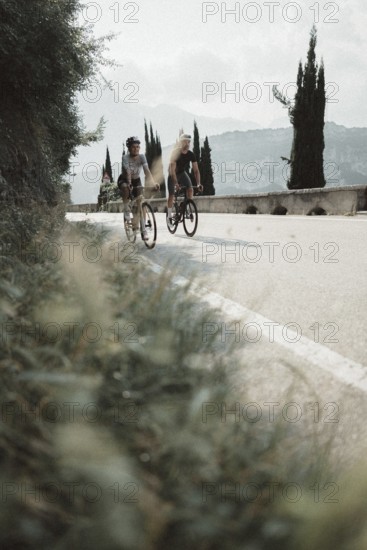 Woman and man riding racing bikes in Italy on Lake Garda