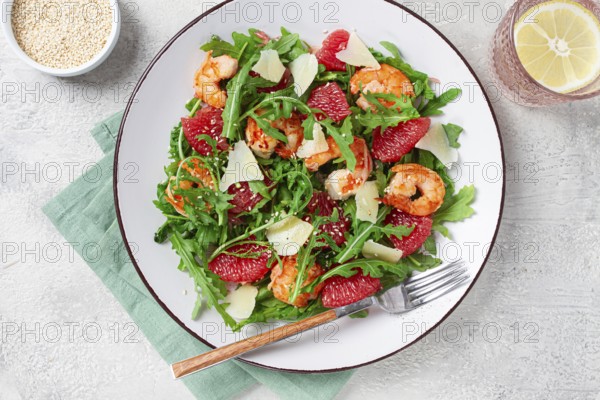 Fresh shrimp salad with arugula, grapefruit, and parmesan served in a bowl