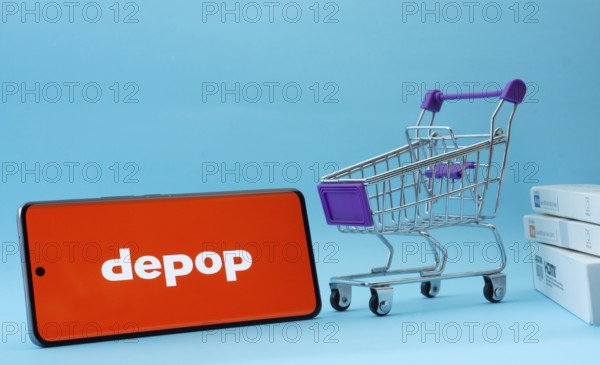 Dhaka, Bangladesh- 03 July 2025: Smartphone with Depop logo next to a small shopping cart and boxes
