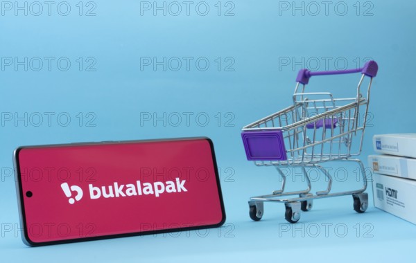 Dhaka, Bangladesh- 03 July 2025: Smartphone with Bukalapak logo next to a small shopping cart and