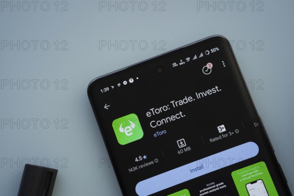 Dhaka, Bangladesh- 29 May 2025: On a blue surface, a smartphone displays the eToro app within the