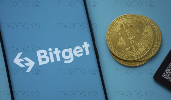 Dhaka, Bangladesh- 22 July 2025: Bitget logo on smartphone screen near Bitcoin coin and QR code on