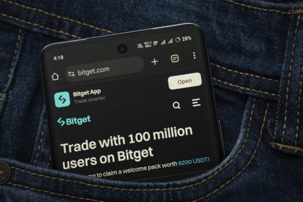 Dhaka, Bangladesh- 15 June 2025: A smartphone displaying the (--).com web interface peeks out of a