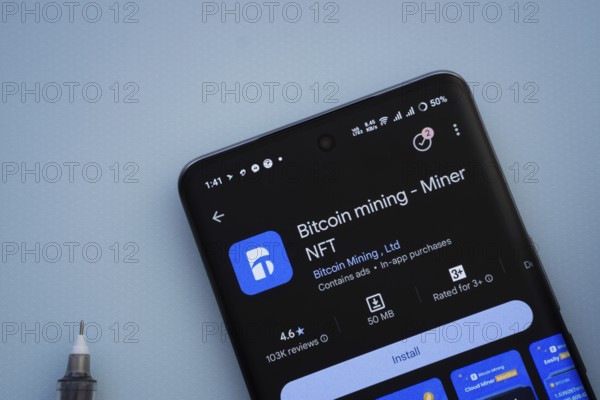 Dhaka, Bangladesh- 29 May 2025: On a blue surface, a smartphone displays the Bitcoin mining app