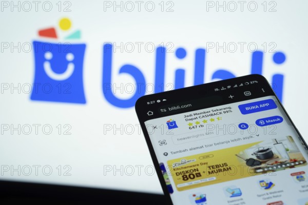 Dhaka, Bangladesh- 03 July 2025: Smartphone displaying Blibli web interface against Blibli logo