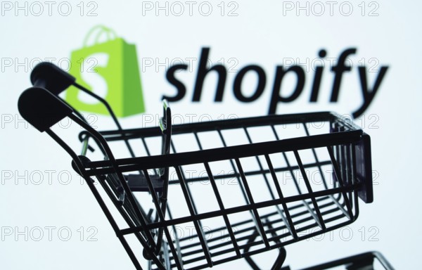 Dhaka, Bangladesh- 03 July 2025: Silhouette of a shopping cart in front of the Shopify logo,