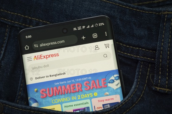 Dhaka, Bangladesh- 15 June 2025: A smartphone displaying the AliExpress web interface peeks out of