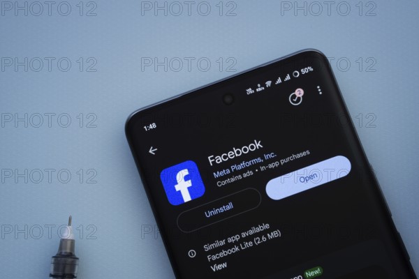 Dhaka, Bangladesh- 29 May 2025: On a blue surface, a smartphone displays the Facebook app within