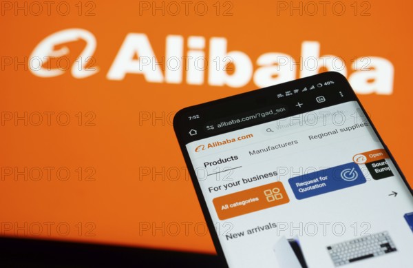 Dhaka, Bangladesh- 03 July 2025: Smartphone displaying Alibaba web interface against Alibaba logo