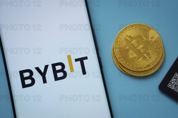 Dhaka, Bangladesh- 15 July 2025: Bybit logo on smartphone screen near Bitcoin coin and QR code on