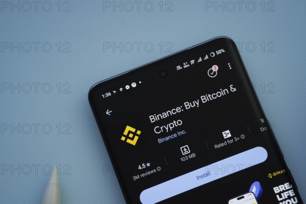 Dhaka, Bangladesh- 29 May 2025: On a blue surface, a smartphone displays the binance app within the
