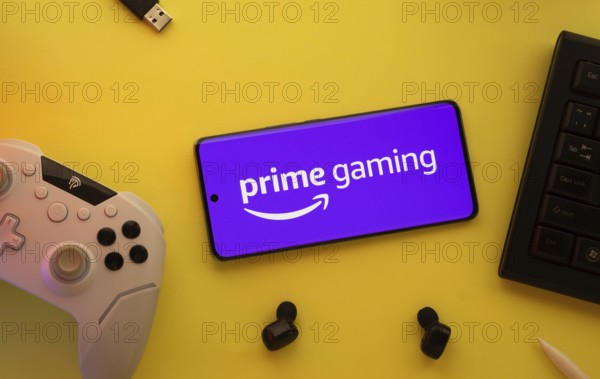 Dhaka, Bangladesh- 22 June 2025: Smartphone with prime gaming logo, game controller, and earbuds on