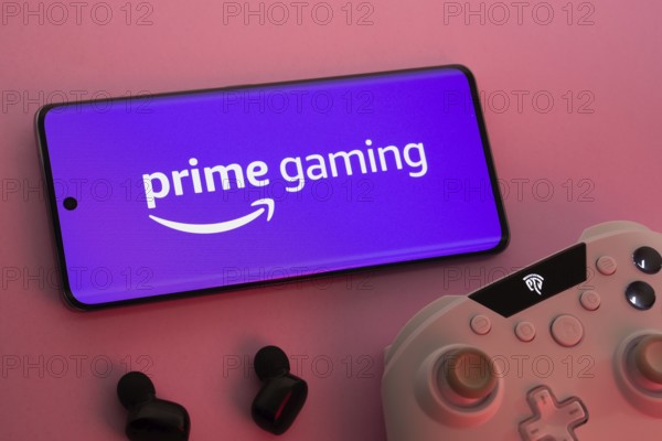 Dhaka, Bangladesh- 22 June 2025: Smartphone with prime gaming logo, game controller, and earbuds on