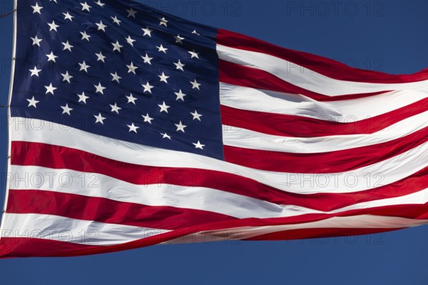 American flag waving in the wind against deep blue sky