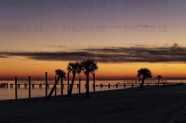 Sunset behind dilapidated fishing pier damaged by hurricanes on the Mississippi Gulf Coast in Long