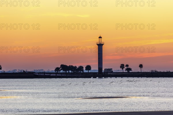 Sunrise silhouette of Broadwater Beach Marina Light at Biloxi, Mississippi, USA