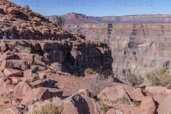 Visitors walk along the canyon rim to the location of the old mining cable structure at Guano Point