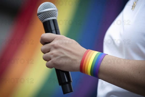 Rainbow wristband on a person holding a microphone during pride activism. Generative AI, AI