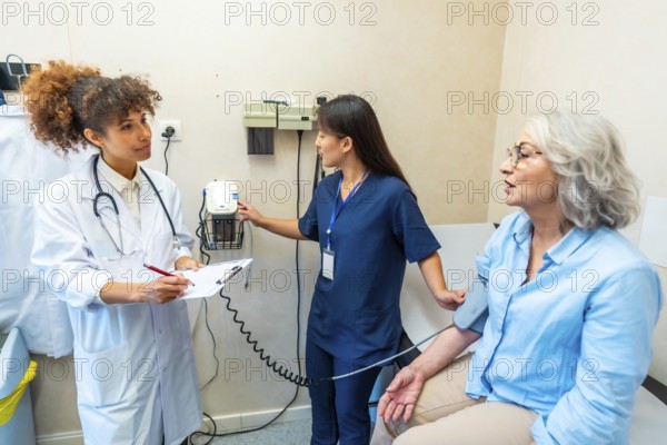 Medical professionals taking care of elderly woman's health, performing blood pressure check in