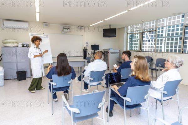 Diverse medical professionals attending a presentation held by a female doctor in a modern hospital