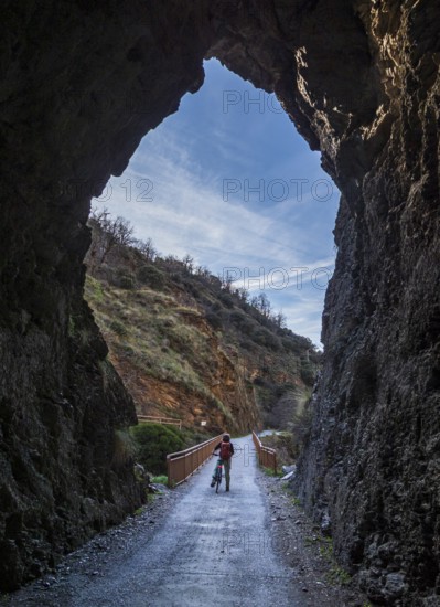 Cyclist on the Tranvía de Sierra Nevada, former railroad track, leading to the trail Vereda de la