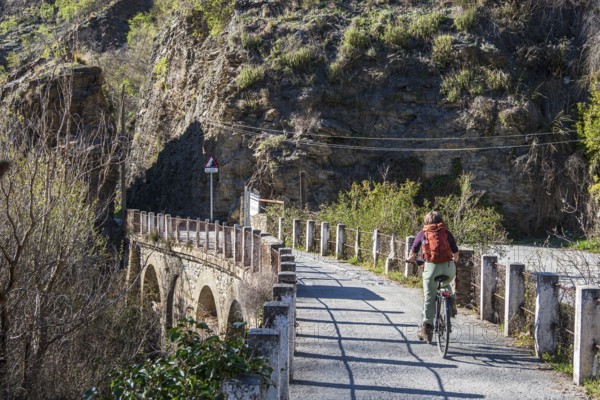Cyclist on the Tranvía de Sierra Nevada, former railroad track, leading to the trail Vereda de la