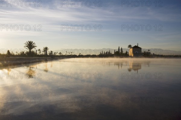 The Menara gardens, basin and minzah, a palace-like pavilion, High Atlas mountains behind, Morocco
