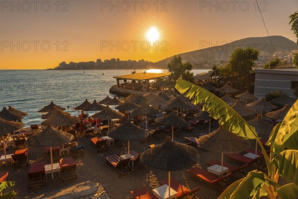 Beautiful resort with umbrellas by the sea at sunset in Sarande or Saranda on the Albanian riviera,