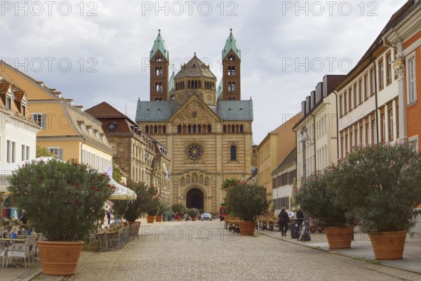 Historic architecture along a cobbled street, Speyer Cathedral in the background under clouds,