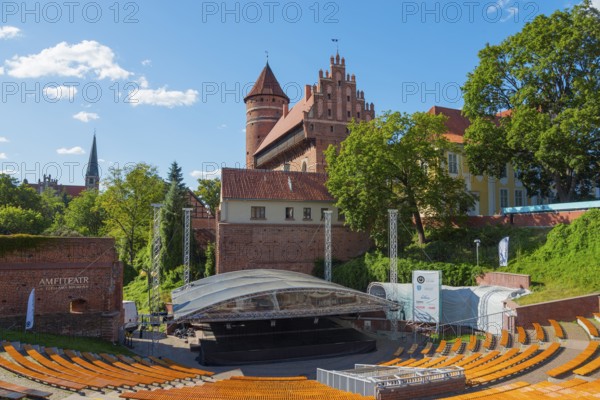 Medieval castle with open-air amphitheatre and surrounding trees, castle and amphitheatre, Olsztyn,