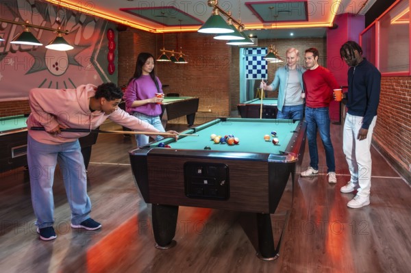Group of multi ethnic friends enjoying a game of billiards in a vibrant entertainment venue,
