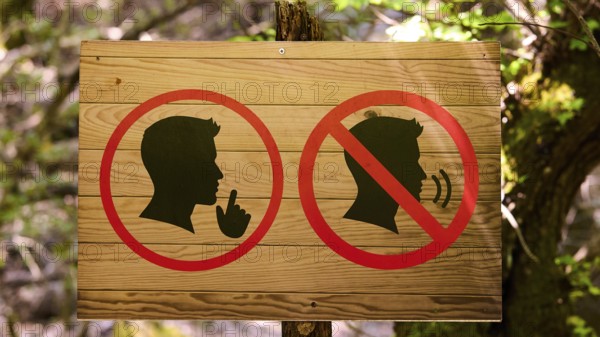 Wooden sign in the forest with symbols indicating peace and tranquillity, Butterfly Valley,