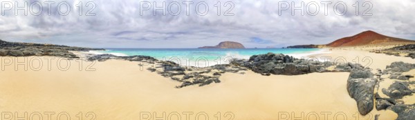 Sandy beach of Playa de las Conchas, volcano Monte Bermeja and island Monta Clara in the