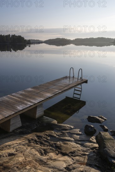 Wooden jetty with ladder, calm water surface, morning atmosphere, Kasnäsintie, Falkö Fjord, Kasnäs,