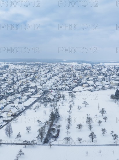 Snowy cityscape with many trees, under a cloudy sky, Deckenpfronn, Böblingen district, Germany