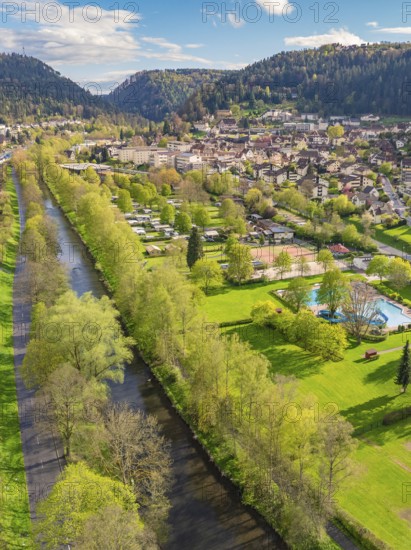 River runs through green landscape near town in mountainous surroundings, Bad Liebenzell, district