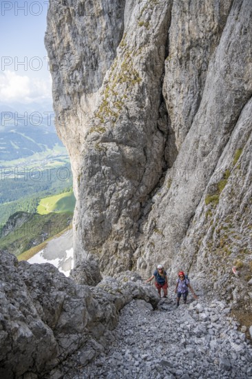 Two mountaineers with helmets climbing on a rock face, ascent to the Ackerlspitze, Wilder Kaiser,