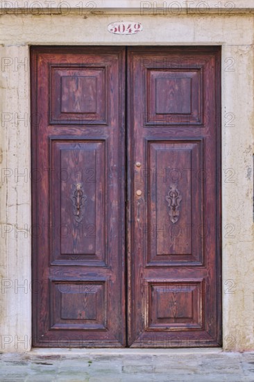 Door of an old house on 'Campo santa margherita' town square in Venice on a sunny day in winter,