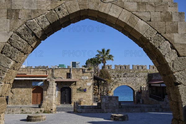 Arched wall overlooking the sea and historic buildings, Rhodes Old Town, Rhodes, Dodecanese, Greek