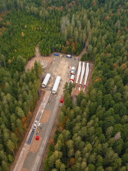 Construction site in the forest with large components and vehicles for the construction of a wind