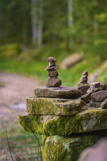 Balanced stone towers on a moss-covered stone along a forest path, Glaswaldsee, Bad