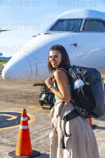 Young woman tourist with backpack arriving at francisco b. Reyes airport on coron island, ready to